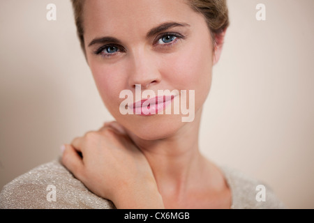 Eine junge Frau mit der Hand auf ihre Schulter, beschnitten Stockfoto