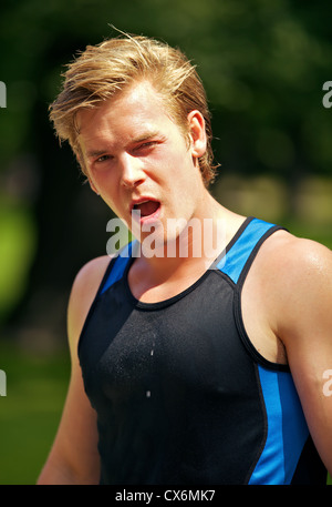 Athletischer Kerl im Park mit einem müden Ausdruck auf seinem Gesicht Stockfoto