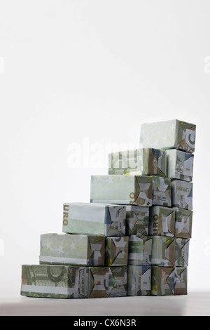 Fünf Euro-Banknoten in rechteckige Kartons gefaltet und in einem Treppenhaus angeordnet Stockfoto