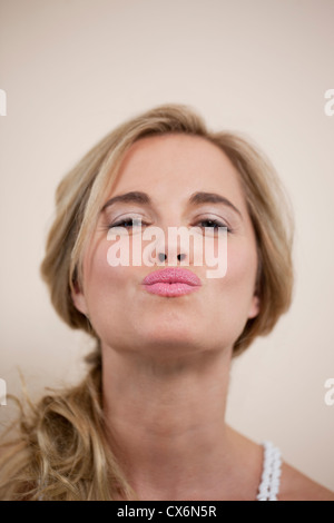 Eine junge Frau bläst einen Kuss Stockfoto