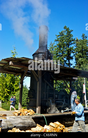 Zuschauern stationäre Ingenieure arbeiten an restaurierten Holz gefeuert Dampf Hilfsmotor Display Campbell River Museum Stockfoto