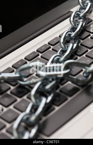 Eine dicke Metallkette umwickelt einen Laptop, Nahaufnahme Stockfoto