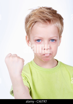 Niedliche kleine Junge droht in die Kamera mit einer Faust Stockfoto