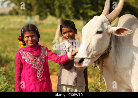 Indische Mädchen und Jungen mit Zebu in einem Feld Andhra Pradesh in Indien Stockfoto