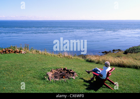 Cape d ' or, Nova Scotia, Kanada - Frau sitzt im Stuhl genießen Ansicht der Küstenlinie entlang der Bay Of Fundy mit Blick auf Minas Basin Stockfoto