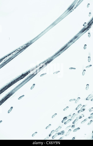 High Angle View of Reifenspuren und Fußspuren im Schnee Stockfoto