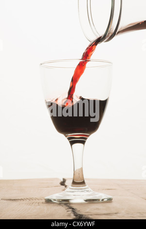 Ein Glas Rotwein aus einer Karaffe gefüllt wird Stockfoto