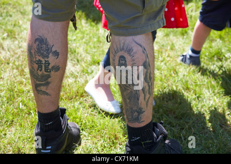 Tattoos auf der Rückseite des mans Beine des Erlösers und Drachen Stockfoto