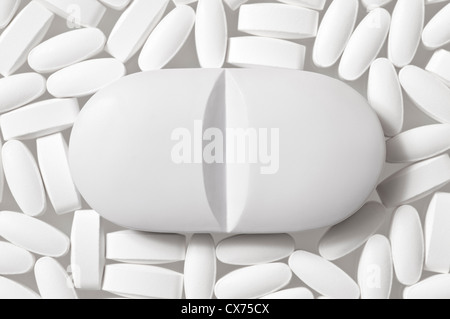 Pillen Ergänzungen Drogen Konzept eine große Pille unter vielen kleineren Pillen Stockfoto