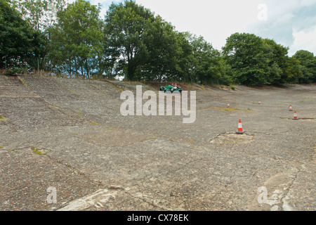 Auto reisen entlang der original erhaltenen Banking bei der Brooklands Motor-Rennstrecke Weybridge, Surrey, UK Stockfoto