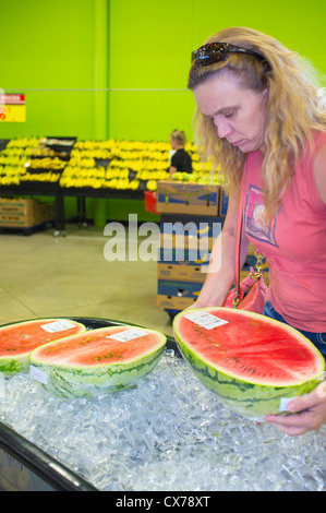 Frau Abholung Wassermelone Hälfte an frische Lebensmittel im Supermarkt Stockfoto