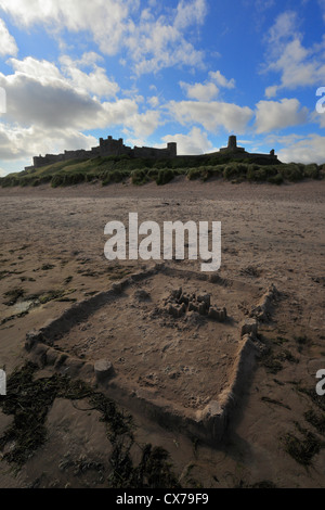 Bamburgh Castle in Northumberland mit einer Sandburg am Ufer im Vordergrund. Stockfoto