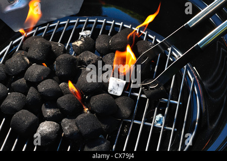 Brennen in einen kleinen tragbaren Grill Holzkohlebriketts Stockfoto