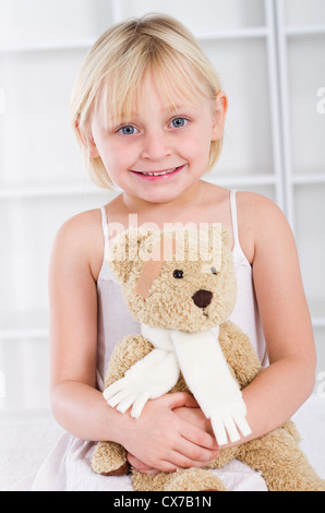 Kleine Mädchen-Patient hält einen Teddybär Stockfoto