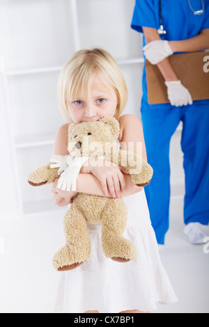 kleines Mädchen mit Teddybär in Arztpraxis Stockfoto