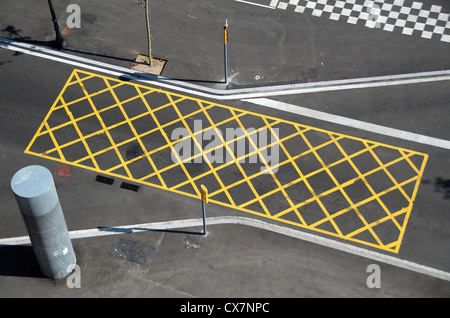 Gelbe Linien auf der Straße zu "keine-stoppen Textbereich" in der Nähe von einer roten Ampel/Kreuzung Stockfoto