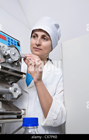 Eine Laborantin passen Sie einen Knopf auf medizinische Diagnosegeräte Stockfoto