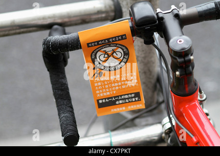 Ein "No Standing" Parkticket für Fahrrad in Englisch und Japanisch Stockfoto