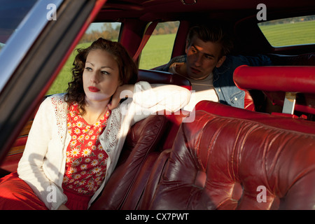 Eine Rockabilly-Frau und Mann sitzt in einem Oldtimer Stockfoto