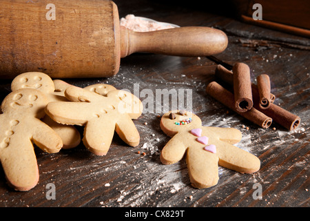 Rolling Pin und hausgemachte Lebkuchenmänner Kekse auf einem Holzbrett mit Mehl Stockfoto