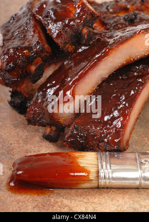 Leckeres BBQ Baby zurück ribs mit würziger Sauce und Sauce Bürste mit Fokus auf der Soße tropft Stockfoto