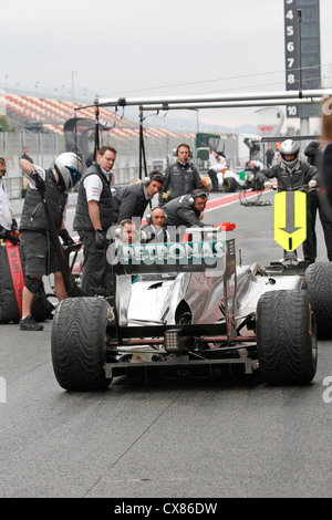 Mercedes GP Mechanik durchführen Boxenstopp auf Nico Rosbergs Auto während des Tests in Montmelo-Rennstrecke in Barcelona, Spanien Stockfoto