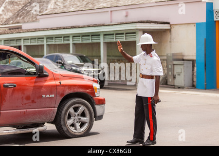 Ein Mitglied der königliche Bahamas Polizei tragen ein Tropenhelm Wolseley leitet den Datenverkehr in Nassau, Bahamas. Stockfoto