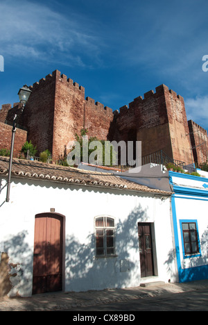 ALGARVE, PORTUGAL. Typische kleine weiß getünchten Häuschen in Silves, mit der maurischen Burg hinter. 2012. Stockfoto