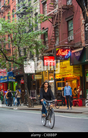 New York City, NY, USA, West Village, Woman Bicycling, Alone, Street Scenes, mit Shop Fronten im Hintergrund, auf MacDougal St., Manhattan, Stockfoto