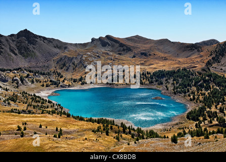 Bild des Lac Allos (2228 m) während ein windiger Tag mit Sonnenlicht Reflexionen über die wellige Wasseroberfläche. Stockfoto