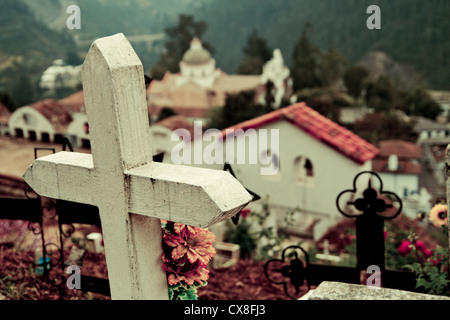 Friedhof in Lateinamerika mit Kreuz und Kirche im Hintergrund Stockfoto