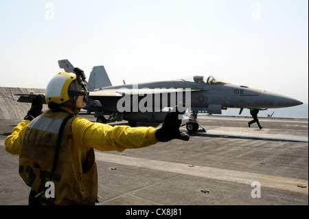 5. US-Flotte BEREICH VON OPERATIONEN (Sept. 17, 2012) der Luftfahrt Bootsmann Mate Airman Abbygail Goranson leitet eine F/A-18E Super Hornet aus dem Pukin Dogs von Strike Fighter Squadron (VFA) 143 auf dem Flugdeck der Nimitz-Klasse Flugzeugträger USS Dwight D. Eisenhower (CVN 69). Dwight D. Eisenhower ist in die USA 5 Flotte Verantwortungsbereich Durchführung Maritime Security Operations eingesetzt, Theater Sicherheit Bemühungen um Zusammenarbeit und Unterstützung von Missionen im Rahmen der Operation Enduring Freedom Stockfoto