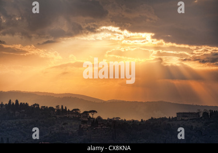 Strahlen des abendlichen Sonnenlicht Strom nach unten auf einem toskanischen Hügel in Florenz, Italien Stockfoto