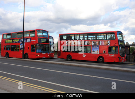 Drei rote Doppeldecker-London-Busse fahren entlang einer Straße in London Stockfoto