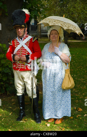 Red Coat Soldaten in uniform Regency posieren mit Dame in Tracht im Park im Stadtzentrum von Bad zu Beginn der Jane Austen Festival Stockfoto