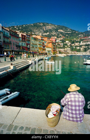 Ein Alter Mann-Fische für kleine Fische in den Hafen des malerischen Riviera Dorf von Villefranche-Sur - Mer, in der Nähe von Nizza, Frankreich Stockfoto