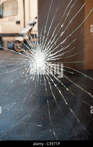 Zerbrochenes Glas-Fenster mit Motorrad im Hintergrund Stockfoto