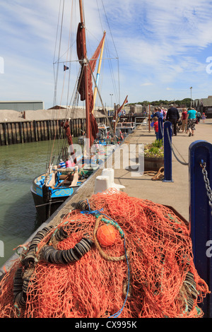 Whitstable Hafen mit bunten Fischernetze am Kai und Segeln Lastkahn Greta in der Themsemündung Whitstable Kent England UK Segeln wird vorbereitet Stockfoto