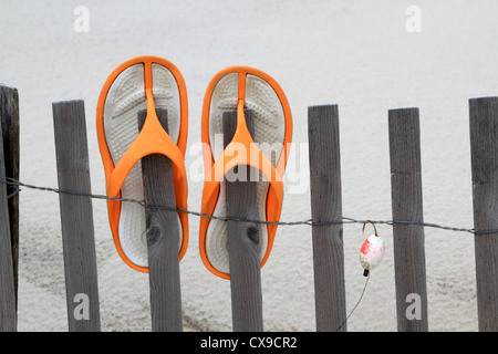 Flip Flops und Fischköder an einem Strand Düne Zaun hängen. Lavalette, New Jersey, USA Stockfoto