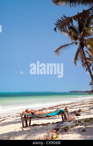 Junges Paar, Sonnenbaden am Strand von Bjewuu, Sansibar Afrika Stockfoto
