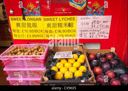 London West End Chinatown essen Lebensmittel grün Lebensmittelladen boxen Store display Körbe süße Longan lychee Indische mango Sharon Früchte Zeichen Chinesisch Stockfoto