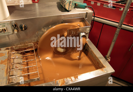 Eine kleine Schokolade mischen Maschine (diesein in eine handgefertigte belgische Chocolaterie verwendet) im Betrieb in einem Geschäft in Belgien. Stockfoto