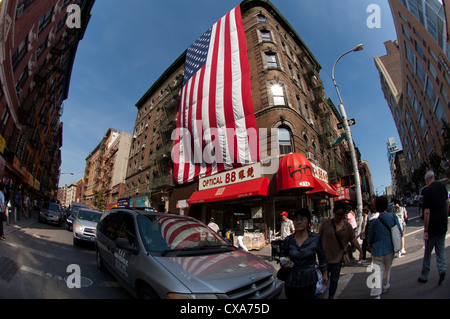 Eine riesige amerikanische Flagge hängt von einem Gebäude an der Mott Street im Stadtteil Little Italy in New York Stockfoto