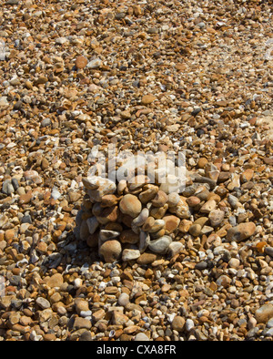 Haufen von Steinen am Strand von anderen Steinen erzeugen eine optische Illusion umgeben Stockfoto