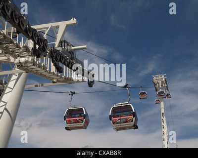 Seilbahnen am North Greenwich mit Pylonen und operativen Getriebe vor blauem Himmel mit Wolkenfetzen Stockfoto