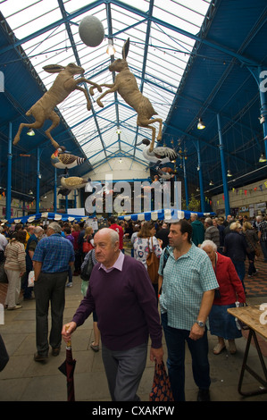 Kunstinstallation von Federwild und springenden Hasen hängen vom Dach der Markthalle in Abergavenny Food Festival Stockfoto