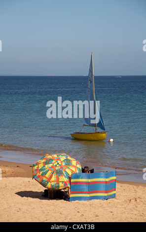 Windschutz, Sonnenschirm und Boot in Swanage am Meer im September Stockfoto