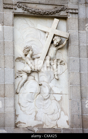 Putten tragen eine Kreuze Skulptur auf äußere Fassade der Kirche Santa Barbara (Salesas Reales) in Madrid, Spanien. Stockfoto