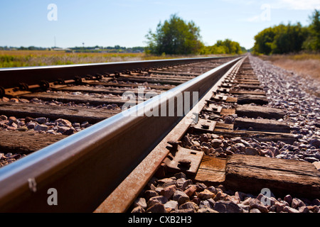 Eisenbahnschienen verschwinden in einer ländlichen Gegend Stockfoto