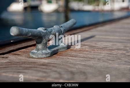 Metall-Klampe auf einem hölzernen Dock. Stollen dienen zur Sicherung der Docks und Linien von Booten Stockfoto